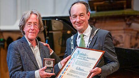 Ed Bausch ontvangt de Muzepenning uit handen van Ernest Briët